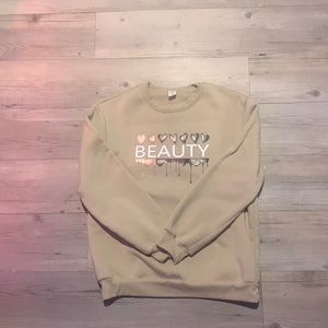 A 11-12 Yourh sized beige crew neck with a  cute design